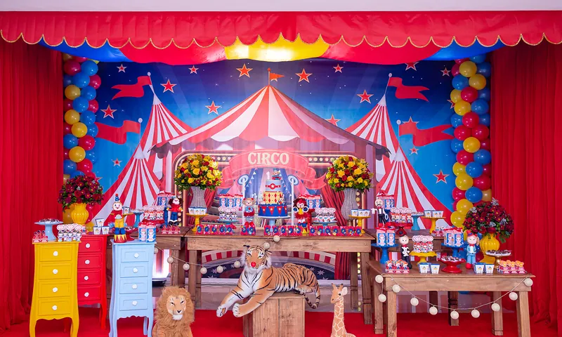 Mesa de circo clássico com cortina vermelha, cômodas coloridas e tigre de pelúcia