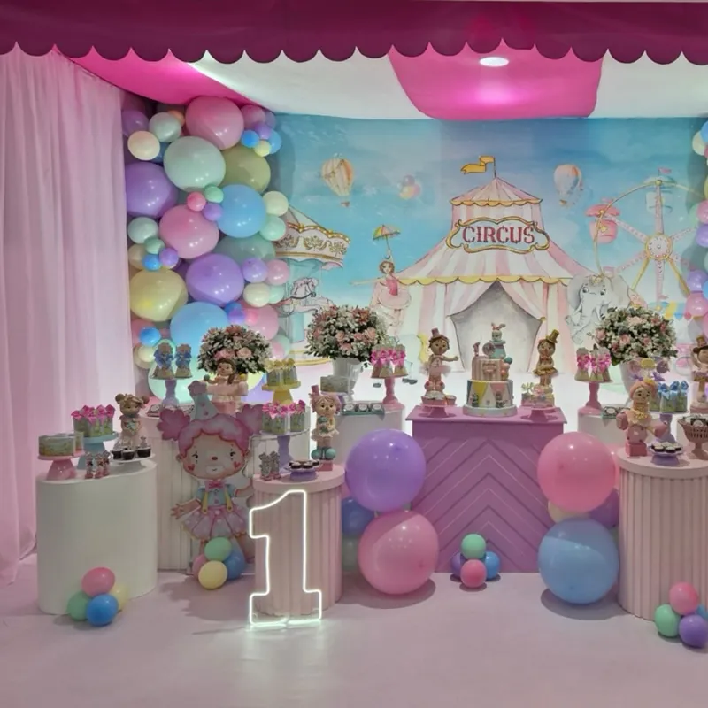 Mesa de festa com tema circo em tons pastel, balões rosa e azul e painel com tenda