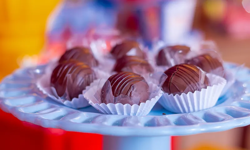 Brigadeiros gourmet em forminhas sobre prato de vidro